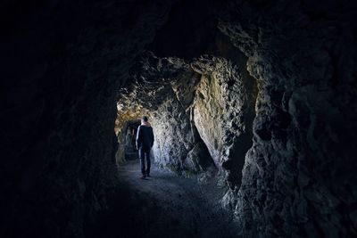 Rear view of man walking in cave