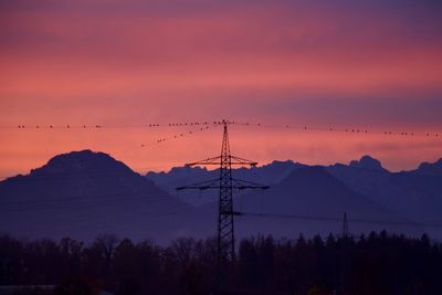 Silhouette trees and mountains against romantic sky at sunset