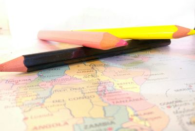 Close-up of colored pencils on world map