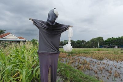 View of scarecrow against cloudy sky