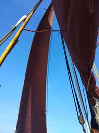 Low angle view of sailboat against clear blue sky