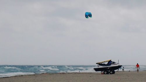 People enjoying at beach against sky