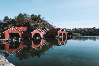 Scenic view of boathouse row on seaside against sky in norway