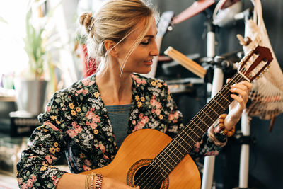 Candid portrait of a smiling woman playing the guitar.