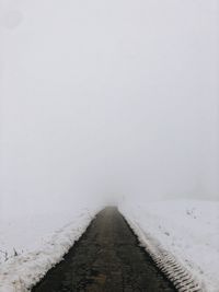 Snow covered land against sky