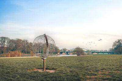 Ferris wheel on field against sky