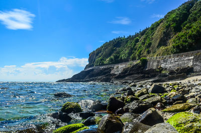 Rocks by sea against sky