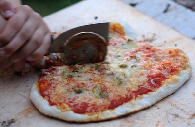 Close-up of hand holding pizza