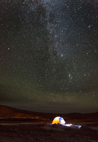 Scenic view of tent against sky at night