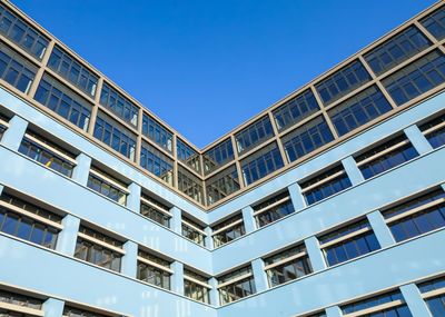 Low angle view of modern building against clear blue sky