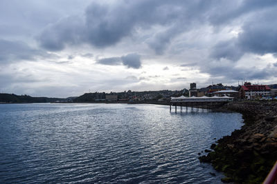 Scenic view of river against sky in city