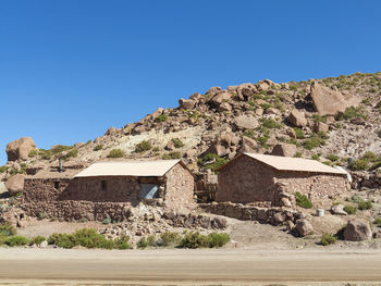 Houses on mountain against clear blue sky