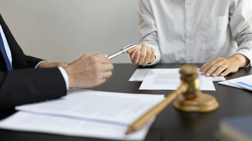 Midsection of lawyer working at desk in office