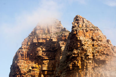 Low angle view of rock formation against sky