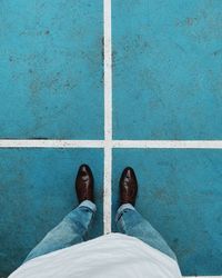 Low section of man standing on tiled floor