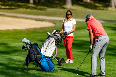 Young couple playing golf on a beautiful summer day