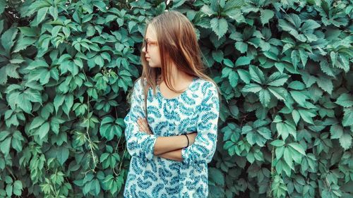 Woman standing by plant