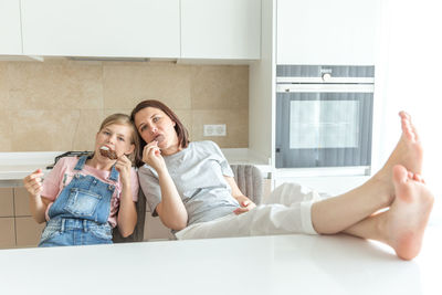 Mother with daughter eating ice cream at home