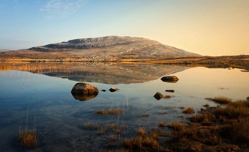 Morning landscape scenery, mountains reflected in lake at burren, county clare, ireland