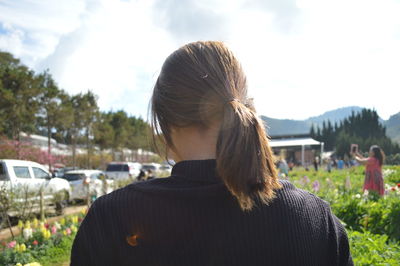 Rear view of woman standing against sky