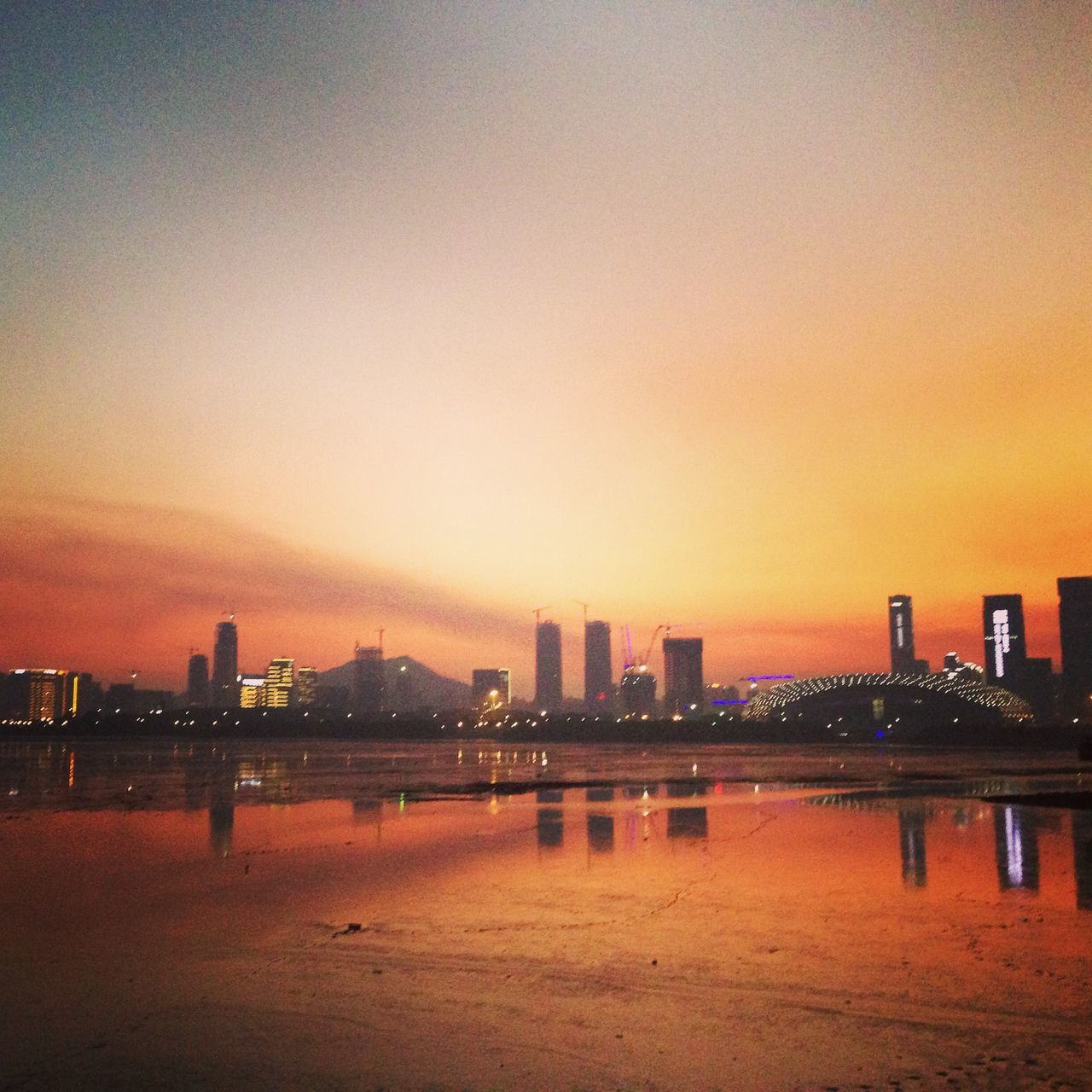 sunset, architecture, built structure, building exterior, city, orange color, illuminated, cityscape, water, copy space, sky, sea, silhouette, river, urban skyline, dusk, bridge - man made structure, clear sky, scenics, skyscraper