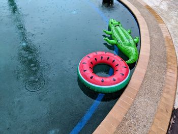 Inflatetable animals drifting in a pool while its raining