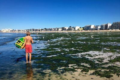 Rear view of woman standing on beach