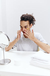 Portrait of young woman drinking water in bathroom