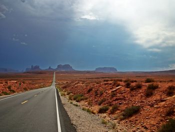 Empty road along landscape against sky