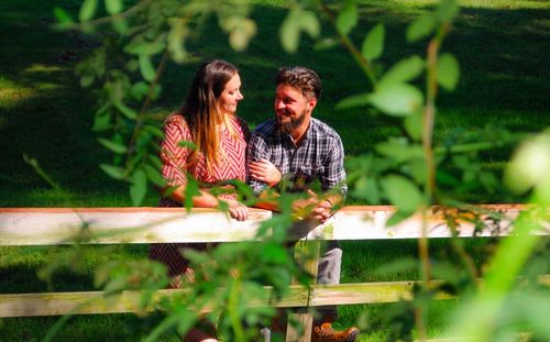 Couple standing by railing against plants