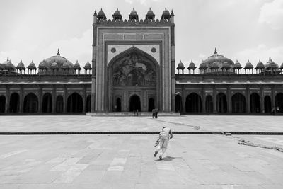 Boy running against building in city