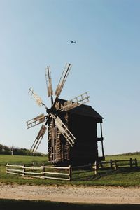 Traditional windmill on field against sky