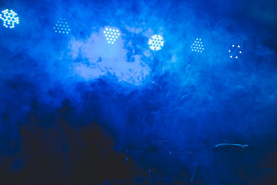 Close-up of illuminated lighting equipment in water at night