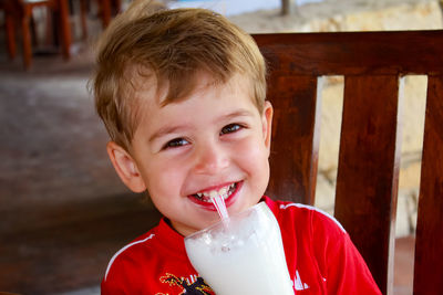 Little boy drinking milkshake through a straw.