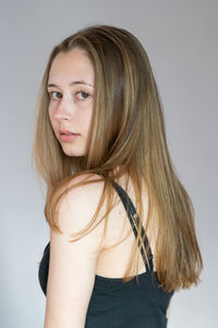 Portrait of beautiful young woman against white background