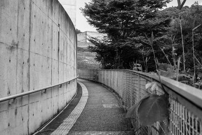 Empty footpath by wall