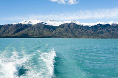 Scenic view of sea and mountains against blue sky