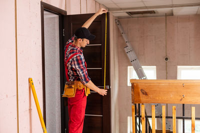 Handyman repair the door lock in the room.