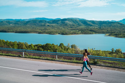 Woman on road by mountain against sky