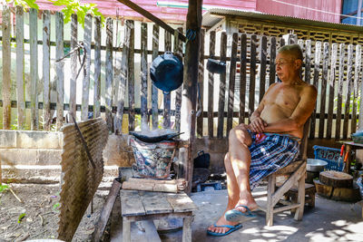 Full length of shirtless man standing outdoors