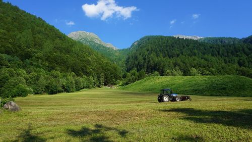 Tractor on grassy field against sky