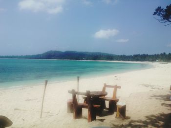 Chairs on beach against sky