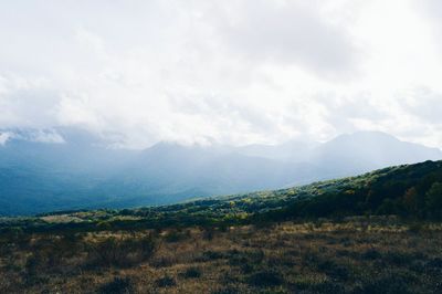 Scenic view of mountains against cloudy sky