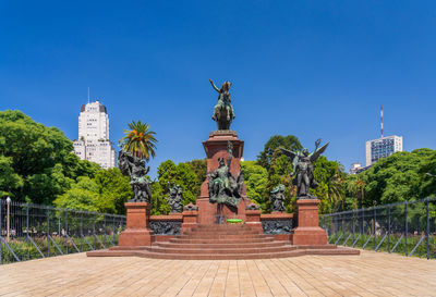 Low angle view of statue against clear blue sky