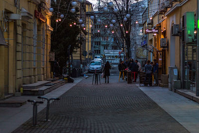 Sidewalk cafe by street in city at night