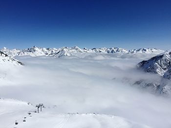 Scenic view of snowcapped mountains covered by clouds