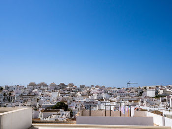 View of cityscape against clear blue sky