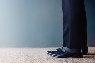 Low section of person standing against wall