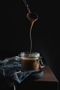 Close-up of drink on table against black background