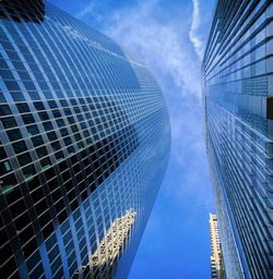 Low angle view of modern buildings against blue sky